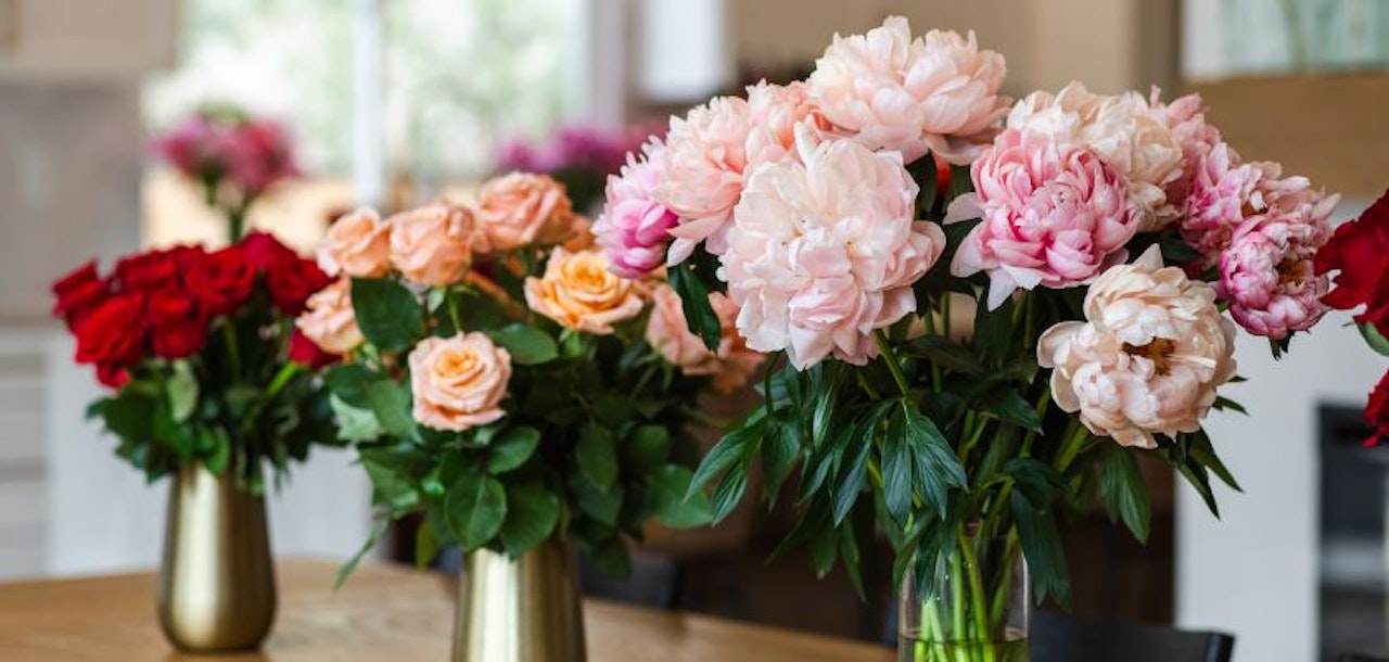 Beautifully arranged peonies and roses in elegant vases, perfect for any celebration or decor.