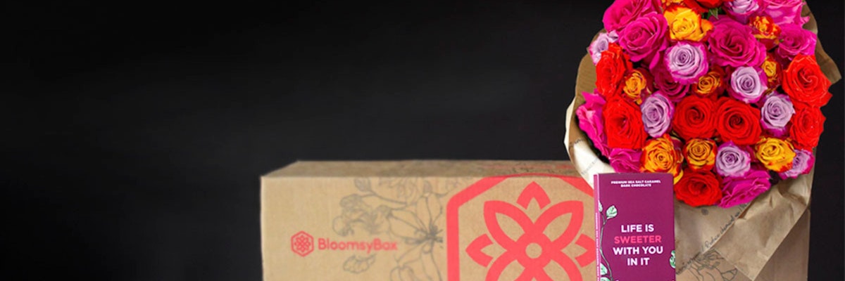 Vibrant floral bouquet featuring red, pink, and lavender roses, packaged in a stylish BloomsyBox.