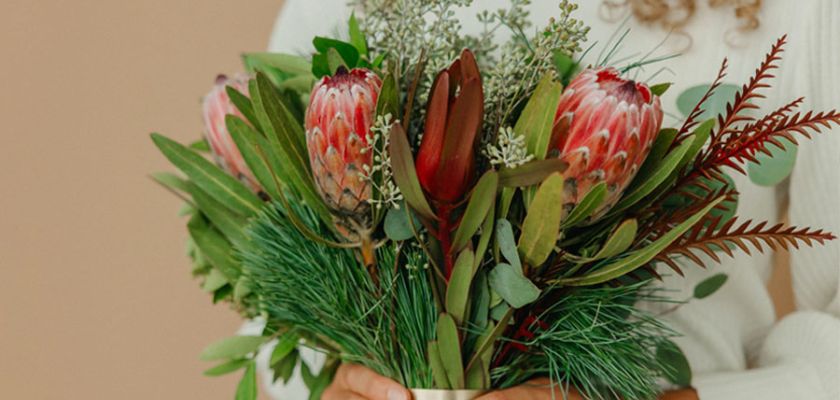 A vibrant bouquet featuring proteas, greenery, and foliage, ideal for any occasion.