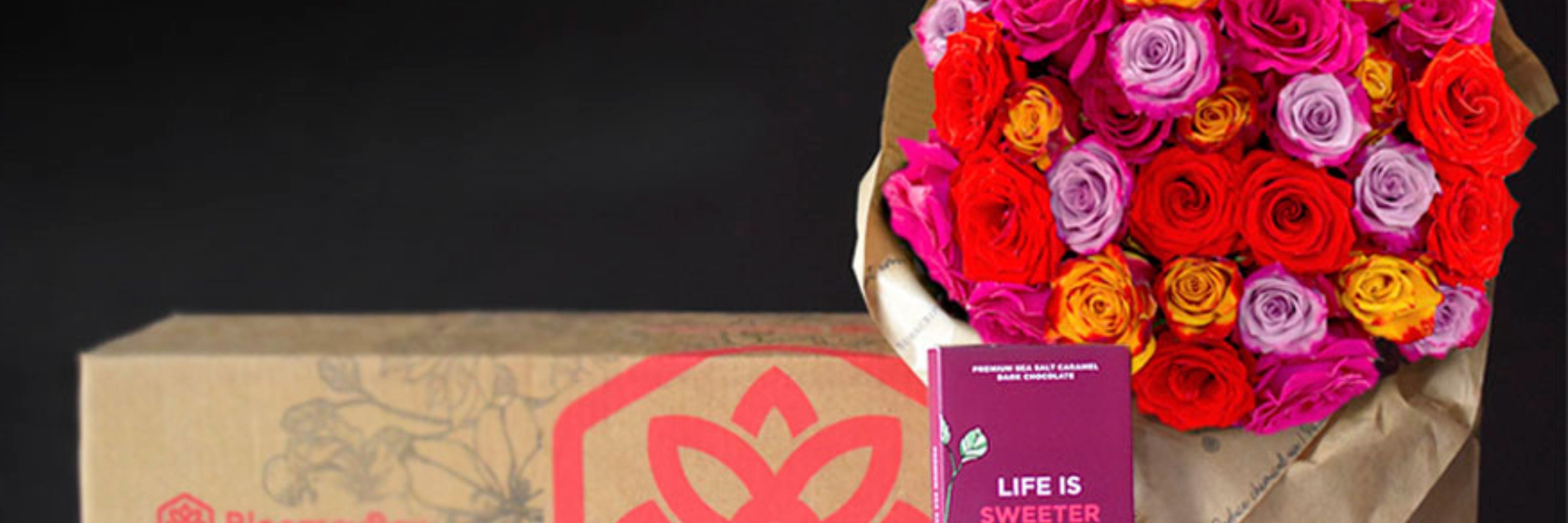 Vibrant bouquet of assorted roses alongside a chocolate treat, perfect for special occasions.