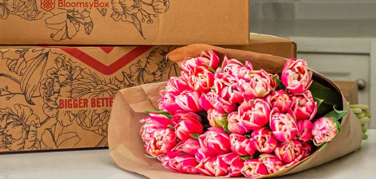 Vibrant bouquet of pink tulips wrapped in craft paper, ideal for celebratory occasions.