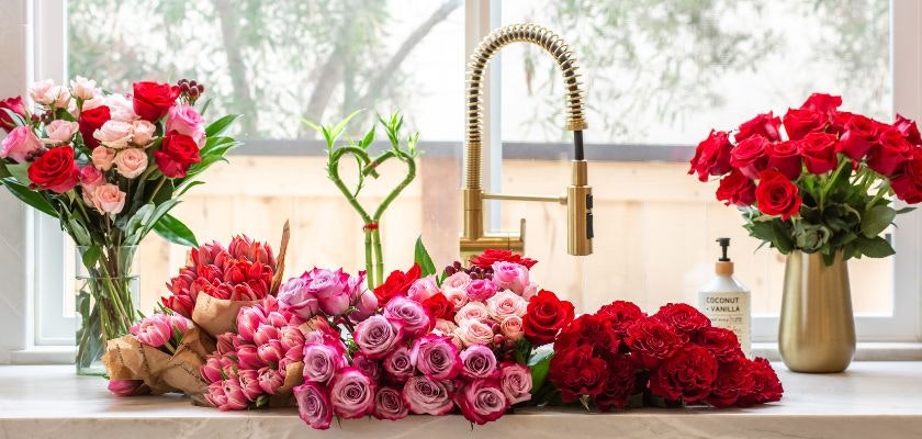 Vibrant floral display featuring red and pink roses, arranged elegantly on a kitchen counter.