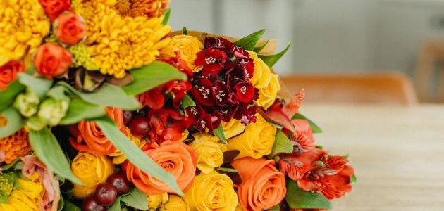 Vibrant floral arrangement featuring orange, yellow, and red blooms in cheerful display.