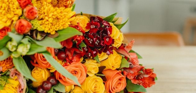Vibrant floral arrangement featuring orange, yellow, and red blooms in cheerful display.