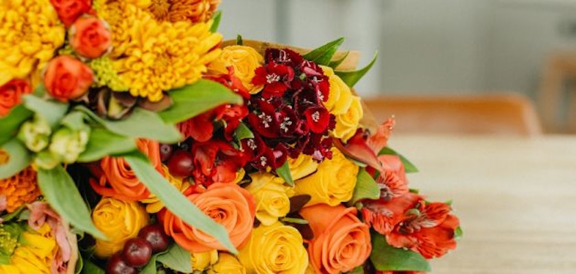 Vibrant floral arrangement featuring orange, yellow, and red blooms in cheerful display.