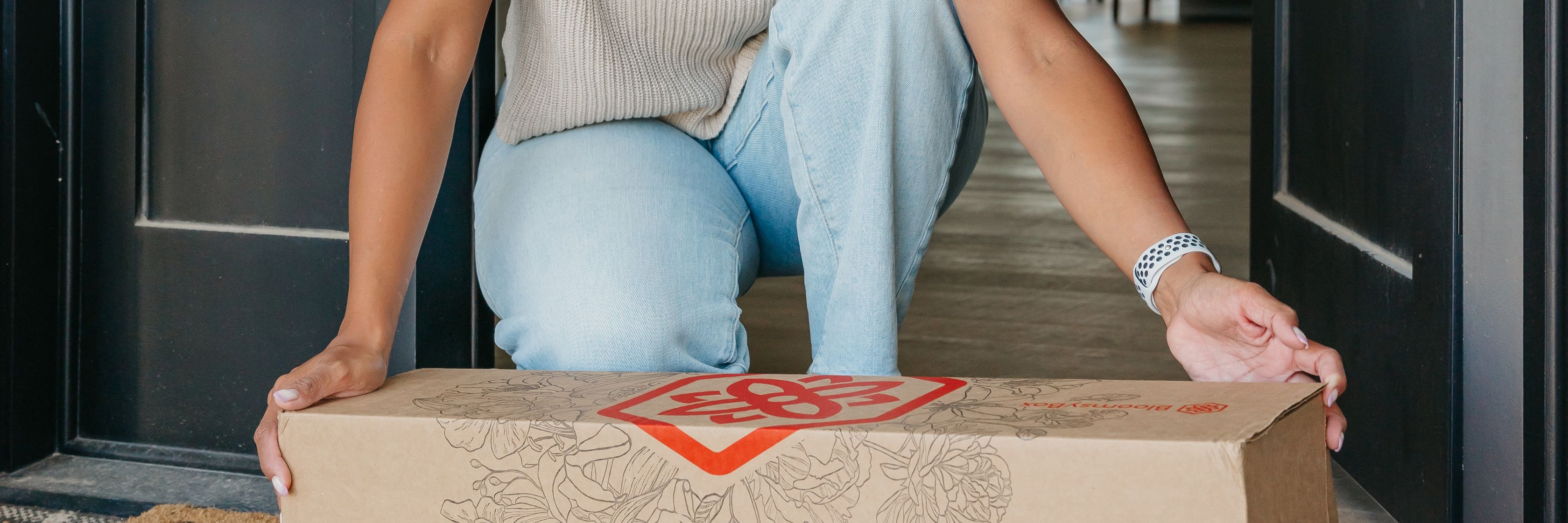 A customer unboxing a floral delivery package at their front door, showcasing elegance and joy.