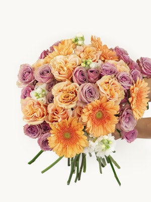 Vibrant bouquet featuring orange gerbera daisies, pink and peach roses, perfect for any celebration.
