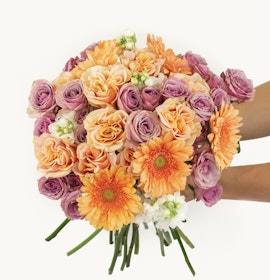 Vibrant bouquet featuring orange gerbera daisies, pink and peach roses, perfect for any celebration.