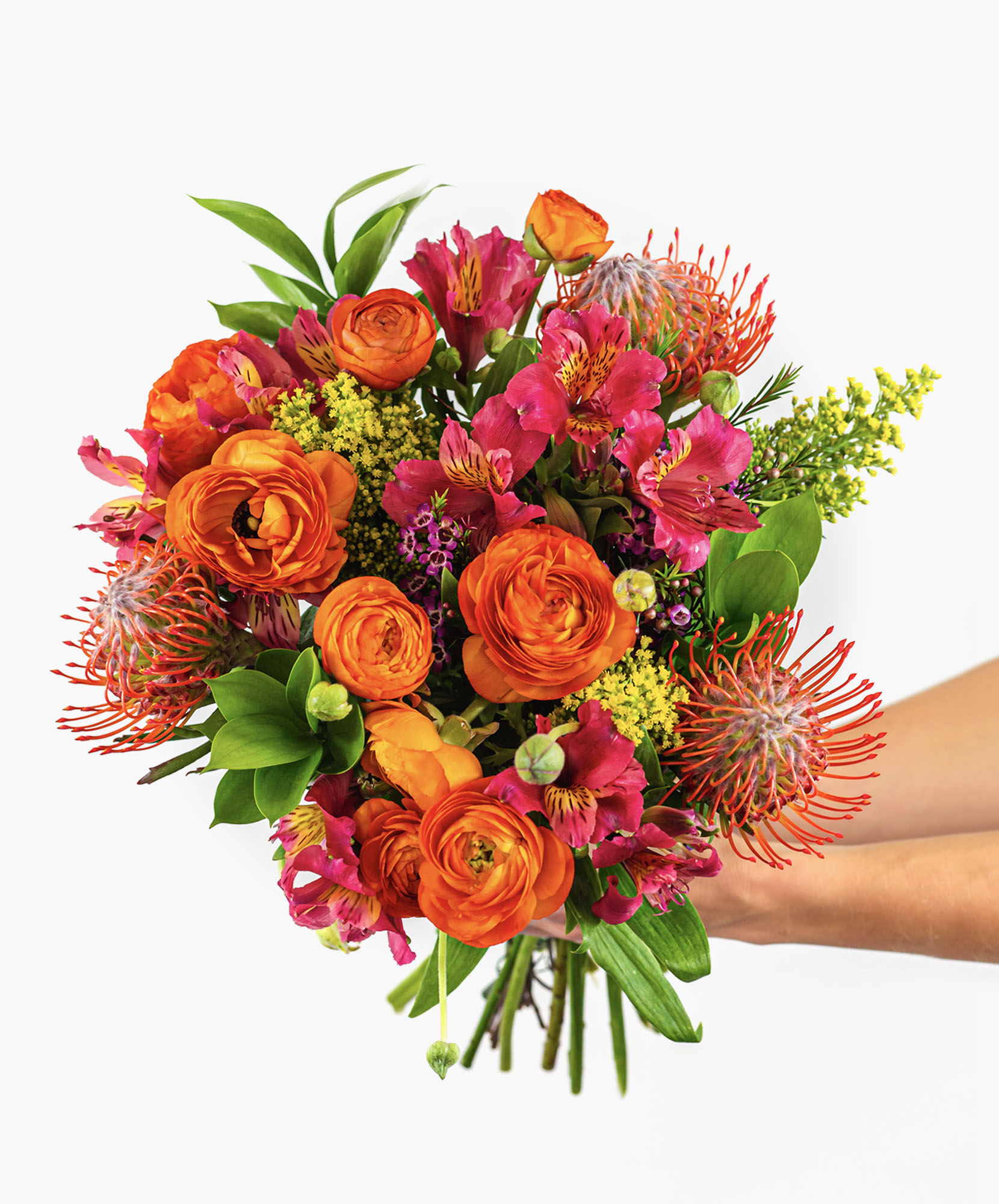 Vibrant bouquet featuring orange ranunculus, protea, and pink alstroemeria blooms.