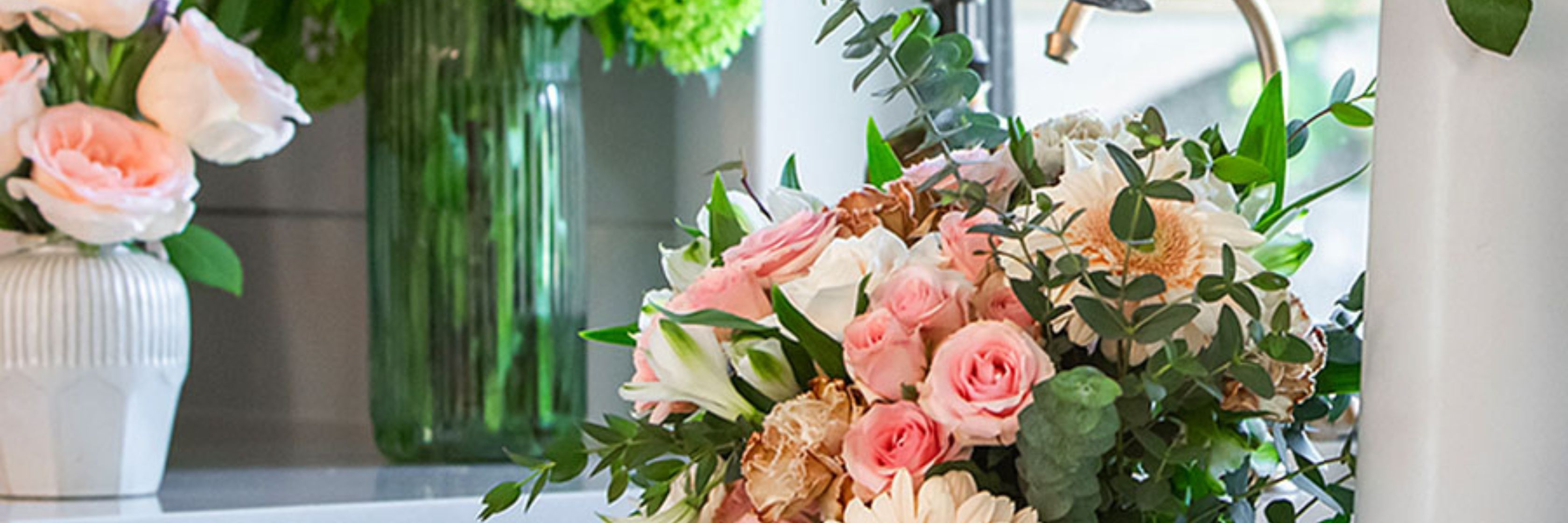 A lush floral arrangement featuring pink roses, white daisies, and greenery for elegant occasions.