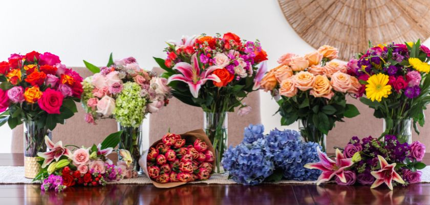 Vibrant floral arrangement featuring roses, lilies, and daisies in various colors and styles.