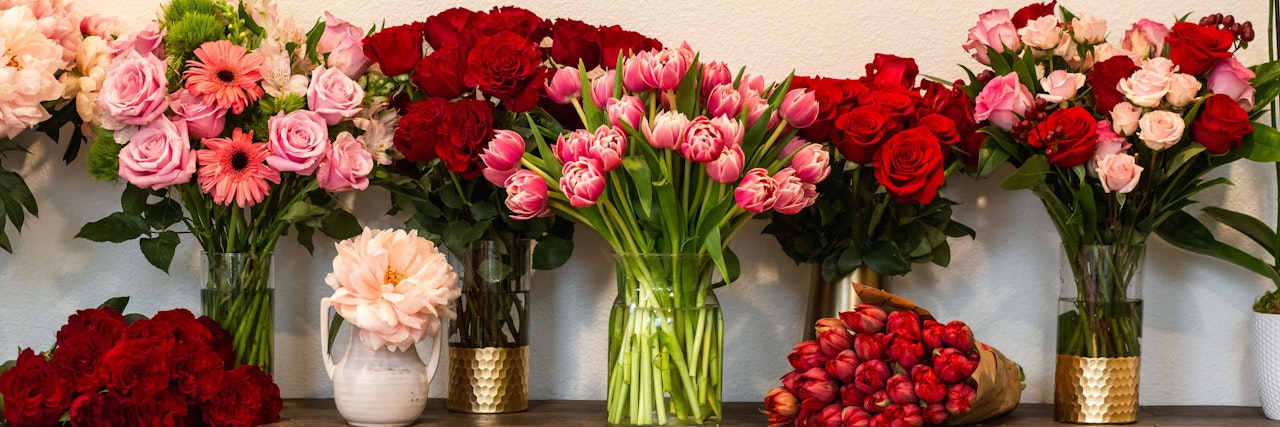 Colorful floral display featuring roses, tulips, and gerbera daisies in elegant vases.