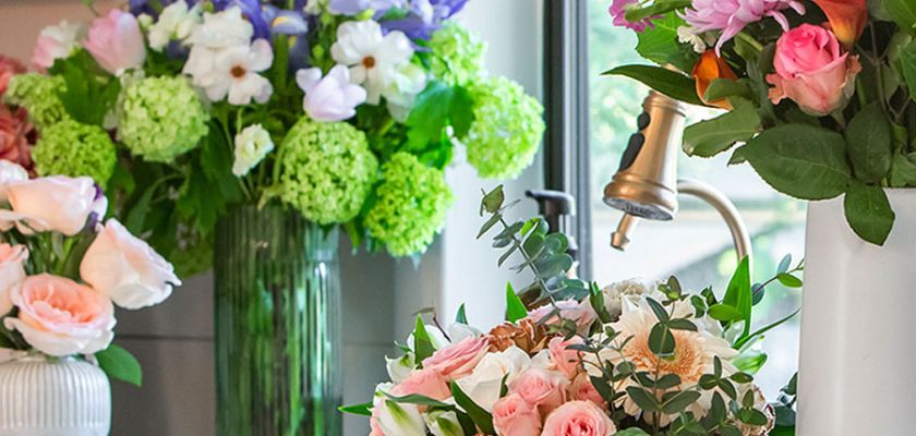 Beautifully arranged bouquets featuring roses, daisies, and greenery in a bright floral space.