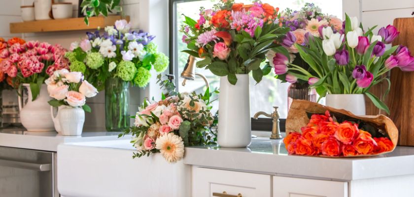 Vibrant floral arrangement featuring various colorful bouquets on a kitchen countertop.