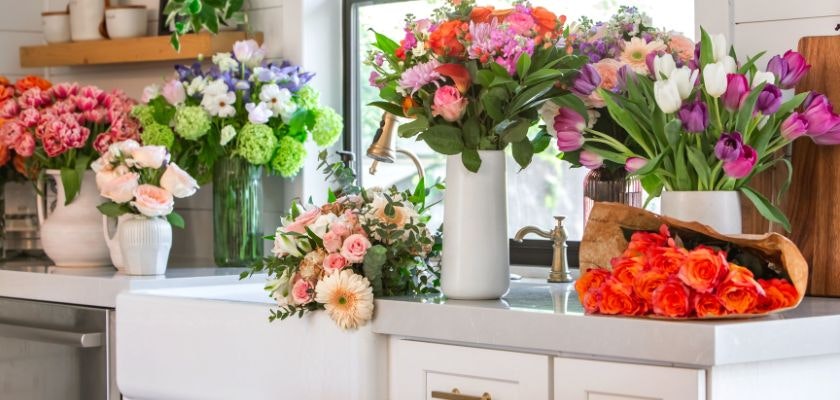 Vibrant floral arrangement featuring various colorful bouquets on a kitchen countertop.