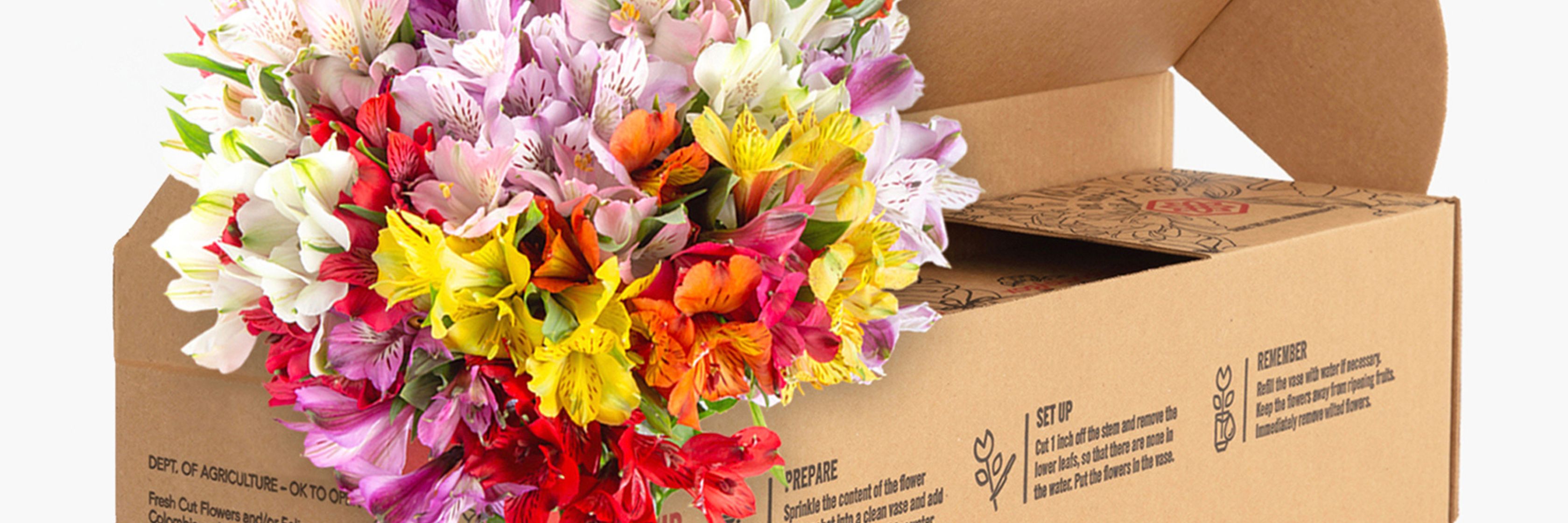 Vibrant mixed bouquet of alstroemeria blooms spilling from a decorative box.