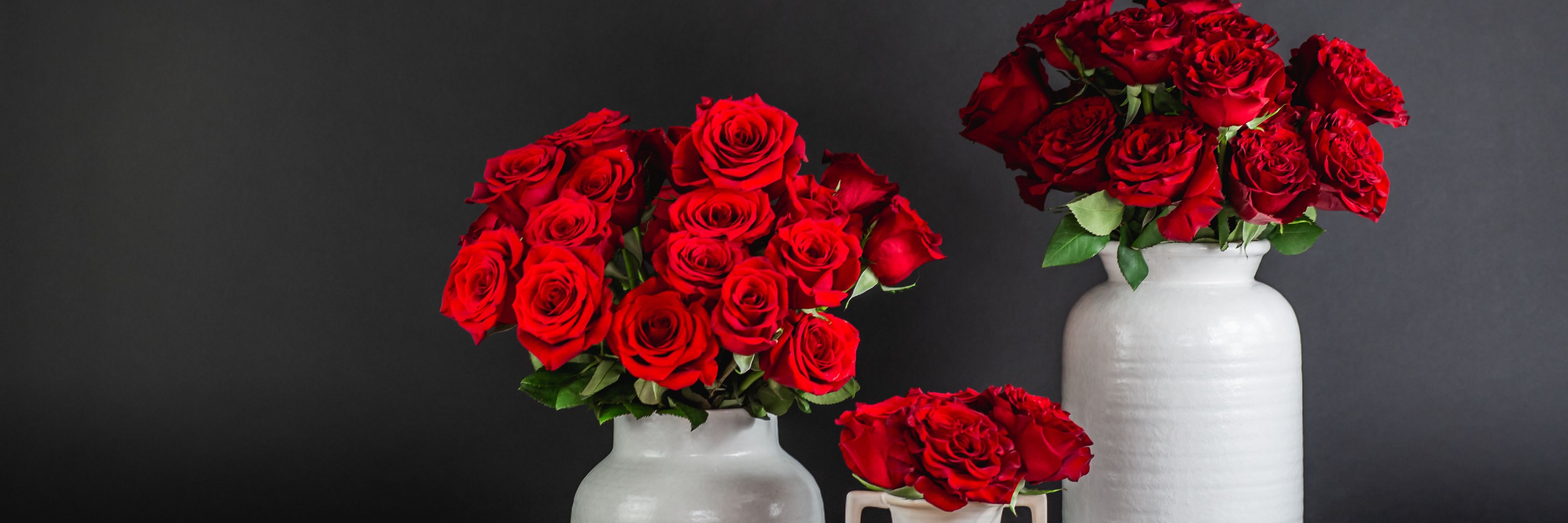 Stunning display of red roses in elegant vases, perfect for romantic occasions.
