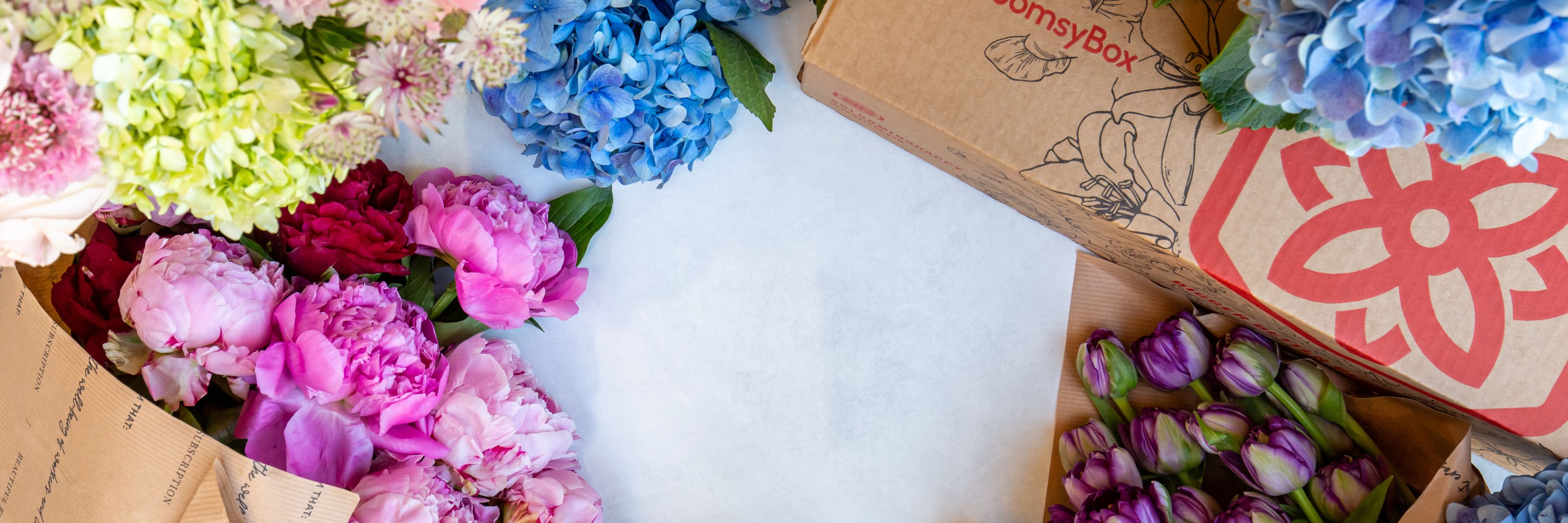 Vibrant floral arrangement featuring peonies, hydrangeas, and tulips in a BloomsyBox display.