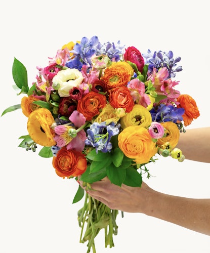 Vibrant bouquet featuring roses, ranunculus, and mixed seasonal blooms in bright colors.