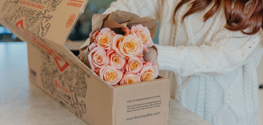 Delivery of a beautiful bouquet of soft pink roses in a BloomsyBox package, ready to enjoy.