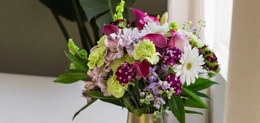 Vibrant flower bouquet featuring lilies, daisies, and colorful blooms in a stylish arrangement.