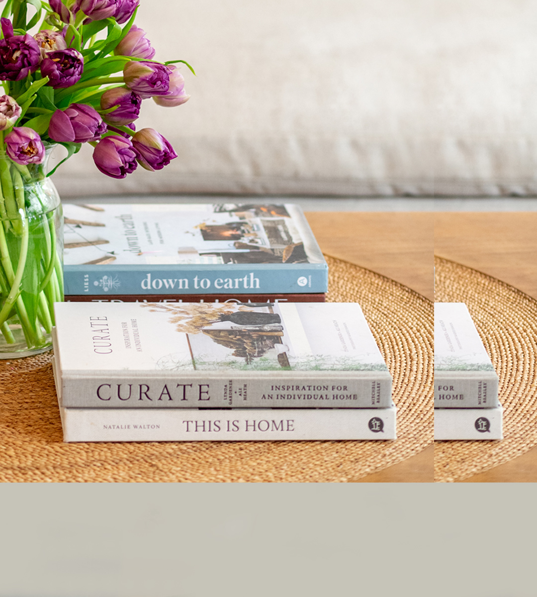 A cozy living room scene featuring a floral arrangement and stacked design books on a table.