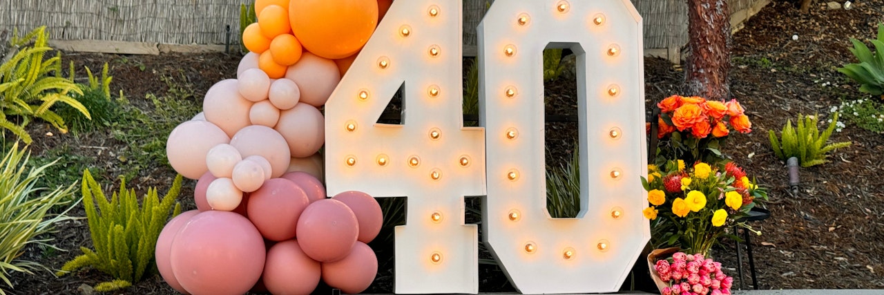 Vibrant 40th birthday celebration display with colorful balloons and blooming flowers.