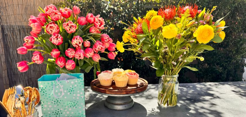 Vibrant floral arrangements with tulips and roses, complemented by delicious cupcakes.