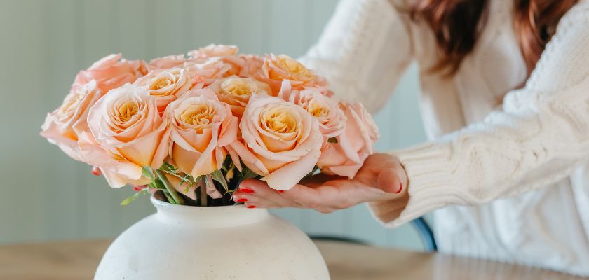 Elegant peach roses arranged in a white vase, perfect for any home decor or special occasion.