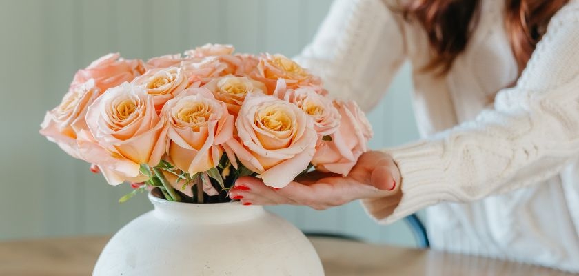 Elegant peach roses arranged in a white vase, perfect for any home decor or special occasion.