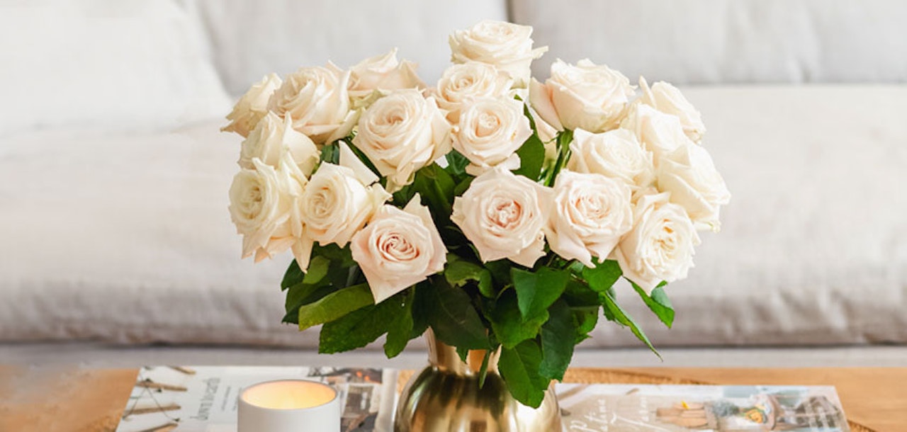 Elegant bouquet of white roses in a gold vase, perfect for any occasion.