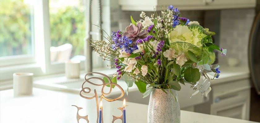 Elegant floral arrangement with purple and white blooms in a stylish vase, brightening the kitchen.