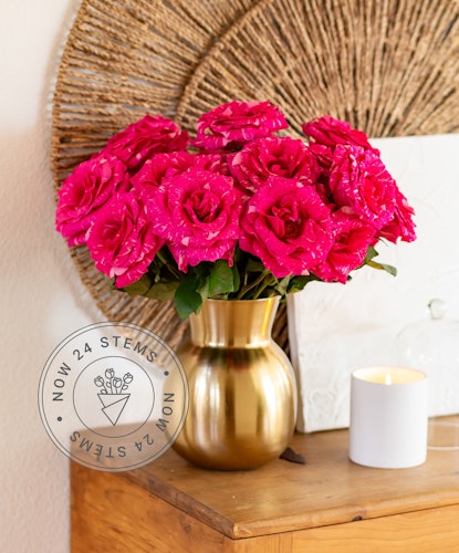 Vibrant pink roses elegantly arranged in a gold vase, perfect for brightening any space.