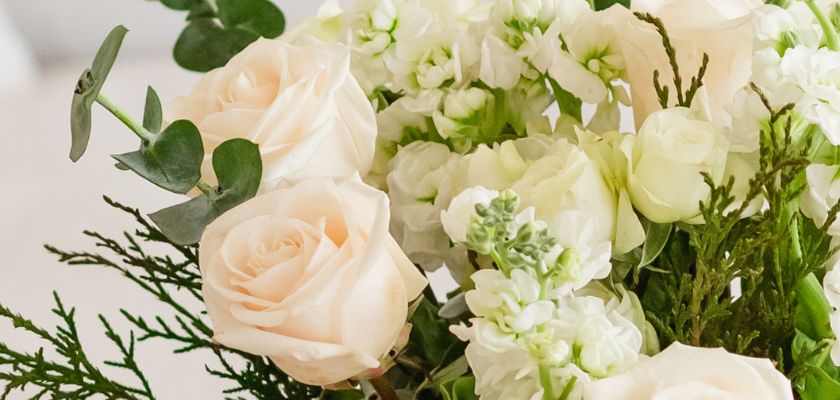 Elegant bouquet featuring soft pink roses and white blooms with lush greenery accents.