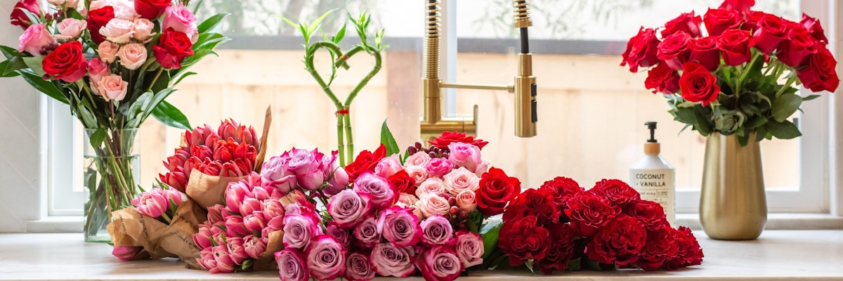A vibrant display of assorted roses and flowers in varying shades, elegantly arranged on a countertop.