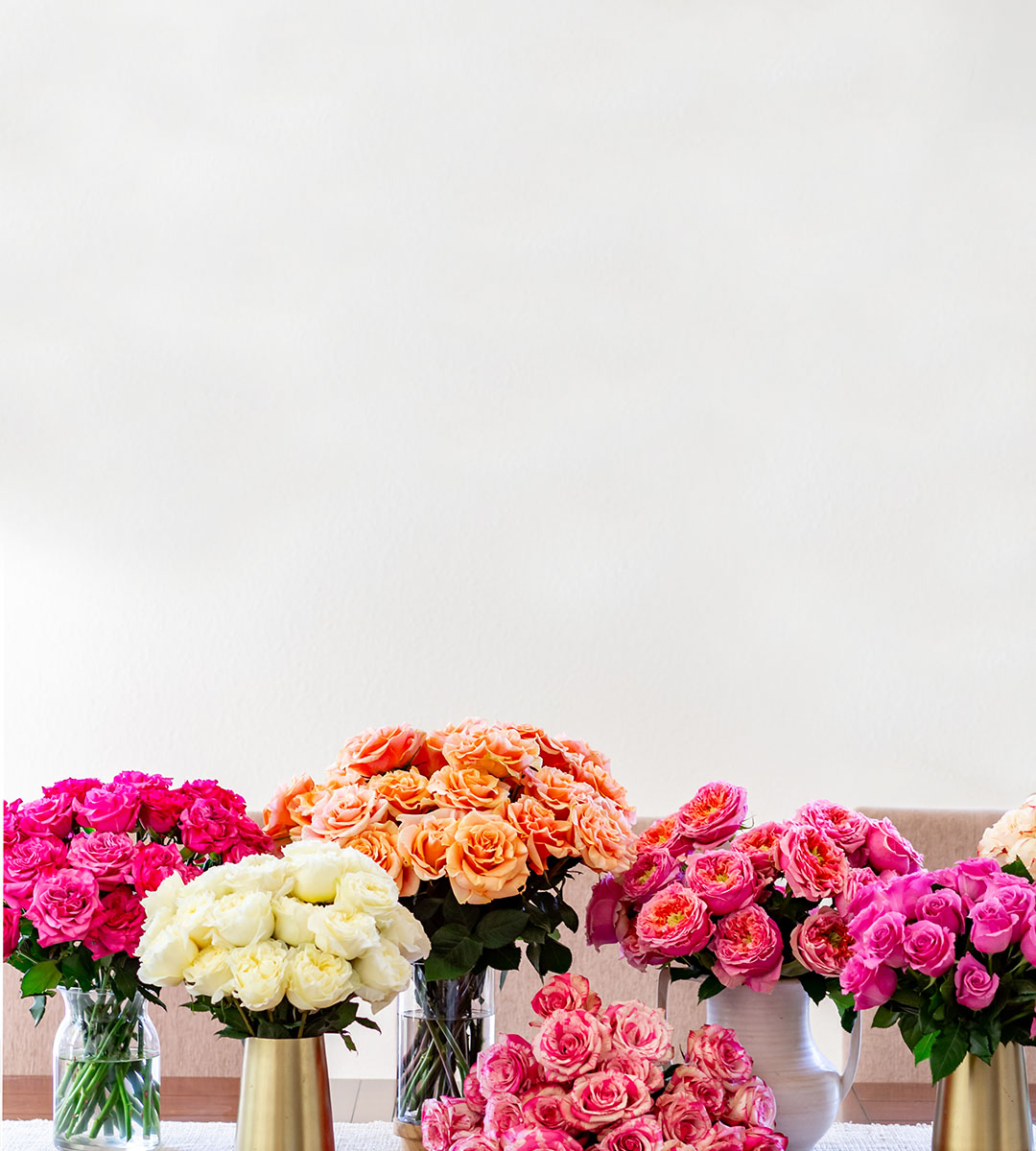 Vibrant display of multicolored rose bouquets in elegant vases, perfect for gifting.