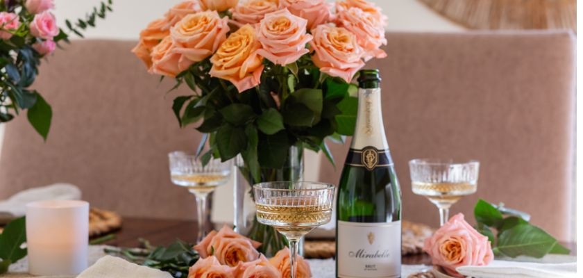 Elegant peach roses in a stunning bouquet alongside sparkling wine glasses for celebrations.