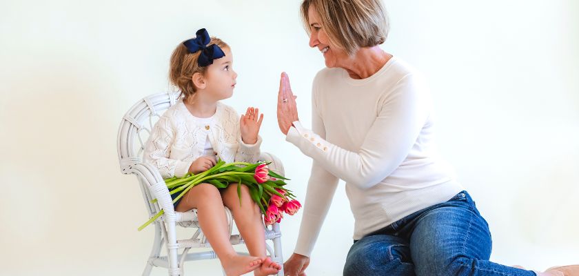 A joyful interaction between a little girl and an adult, surrounded by vibrant tulips.
