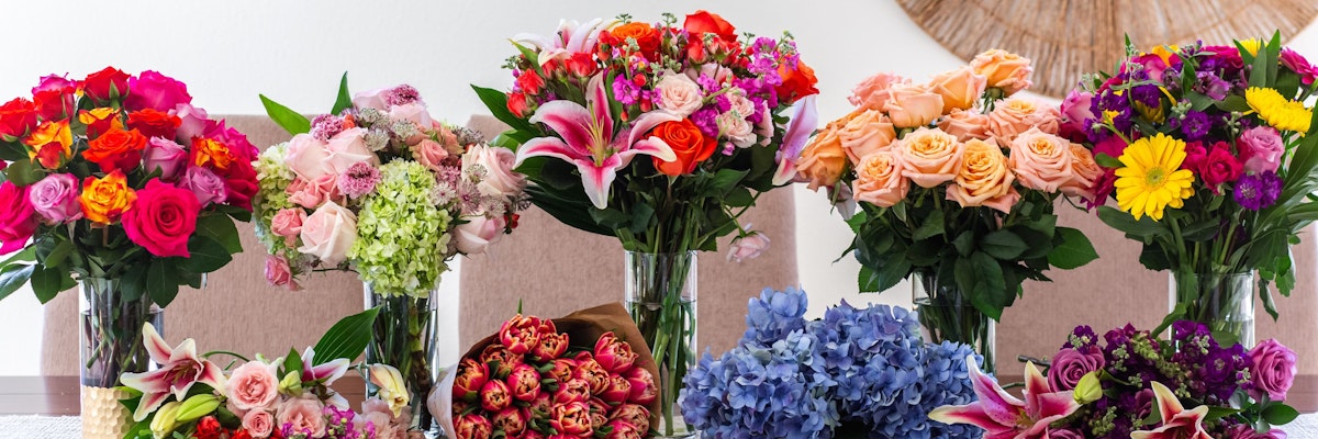 Vibrant assortment of floral bouquets featuring roses, lilies, and colorful blooms in vases.