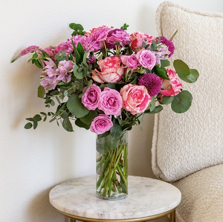 Vibrant pink and purple floral bouquet in a glass vase, perfect for brightening any room.