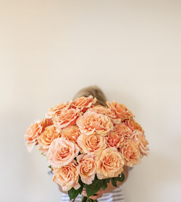 A stunning bouquet of peach roses held close, showcasing soft, romantic blooms.
