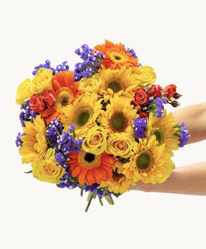 Vibrant bouquet featuring sunflowers, roses, and seasonal blooms in a cheerful arrangement.