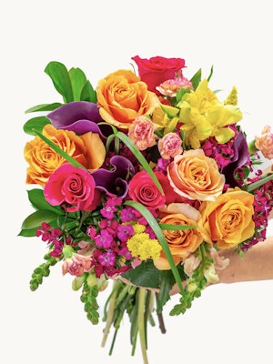 Vibrant bouquet featuring orange roses, purple blooms, and lush greenery, ideal for celebrations.