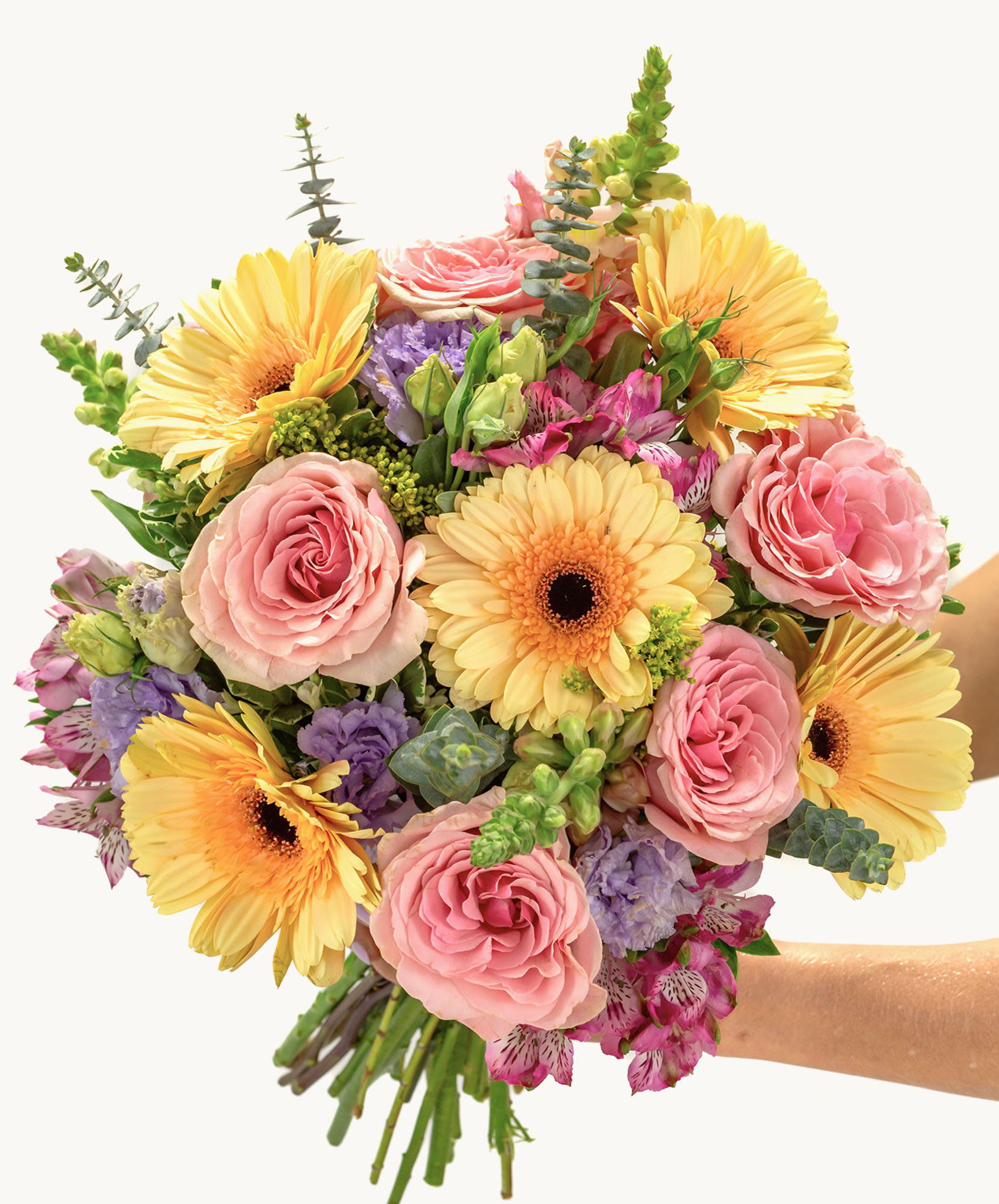 Bright and cheerful bouquet of yellow gerberas, pink roses, and lush greenery.