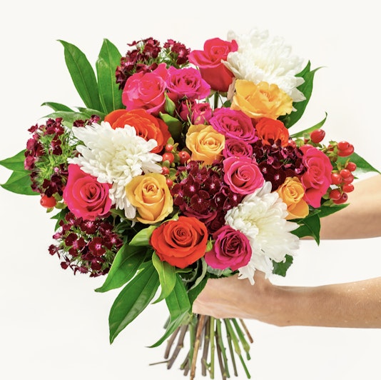 Vibrant mixed flower bouquet featuring roses, chrysanthemums, and lush greenery.