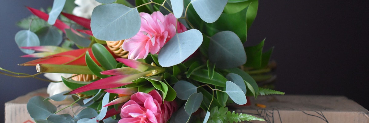 Vibrant bouquet featuring pink flowers and lush green foliage, perfect for brightening any space.