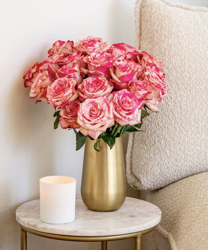 Elegant bouquet of pink and white roses in a gold vase, adding charm to any space.