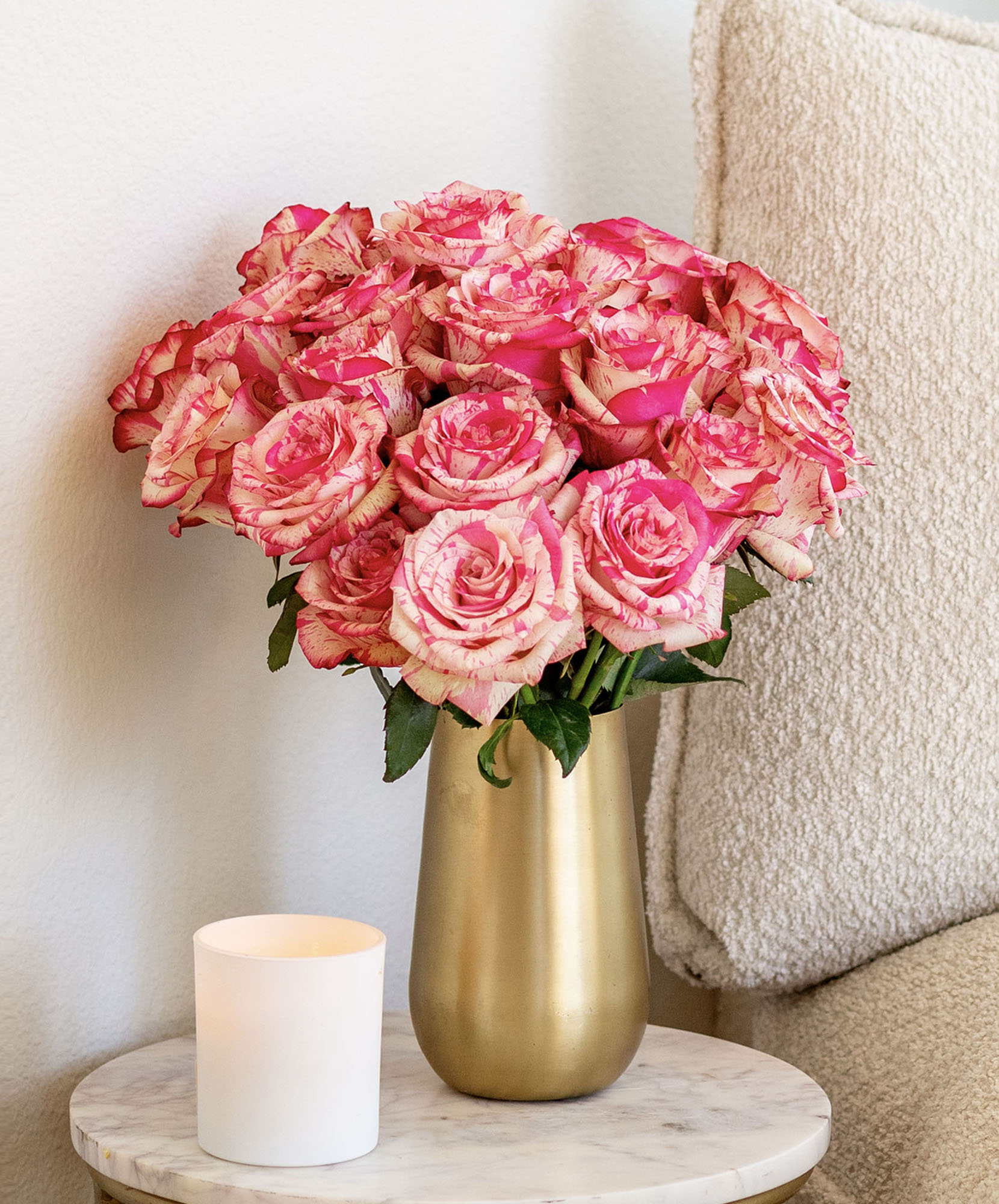 A stunning bouquet of pink and cream roses in a gold vase, perfect for any occasion.