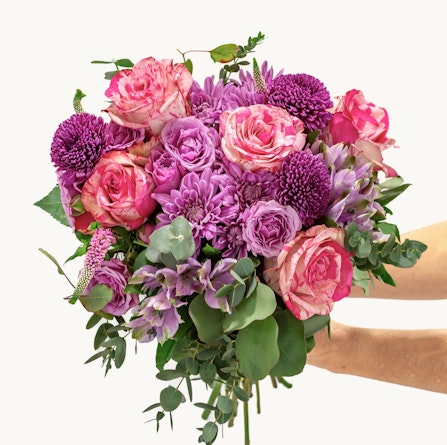 Vibrant bouquet of pink and purple roses, chrysanthemums, and greenery for special occasions.