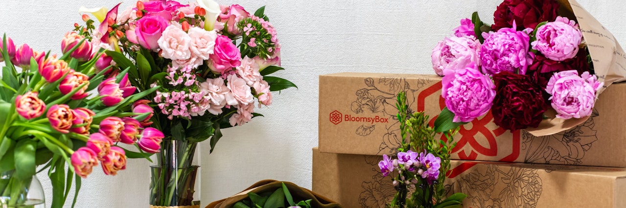 Vibrant floral arrangements from BloomsyBox, featuring pink roses and tulips in elegant vases.